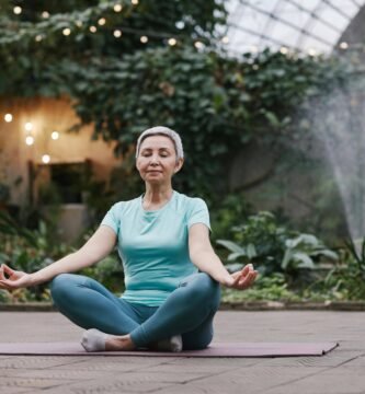 mujer mayor, haciendo yoga en el jardín